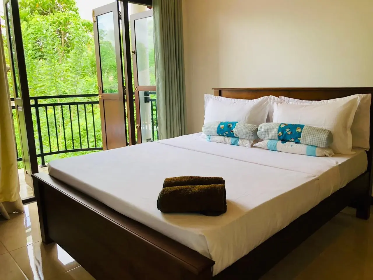 A bedroom at the homestay with open doors facing greenery